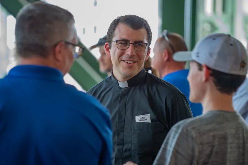 A priest greeting guests during Ballpark Day of Faith